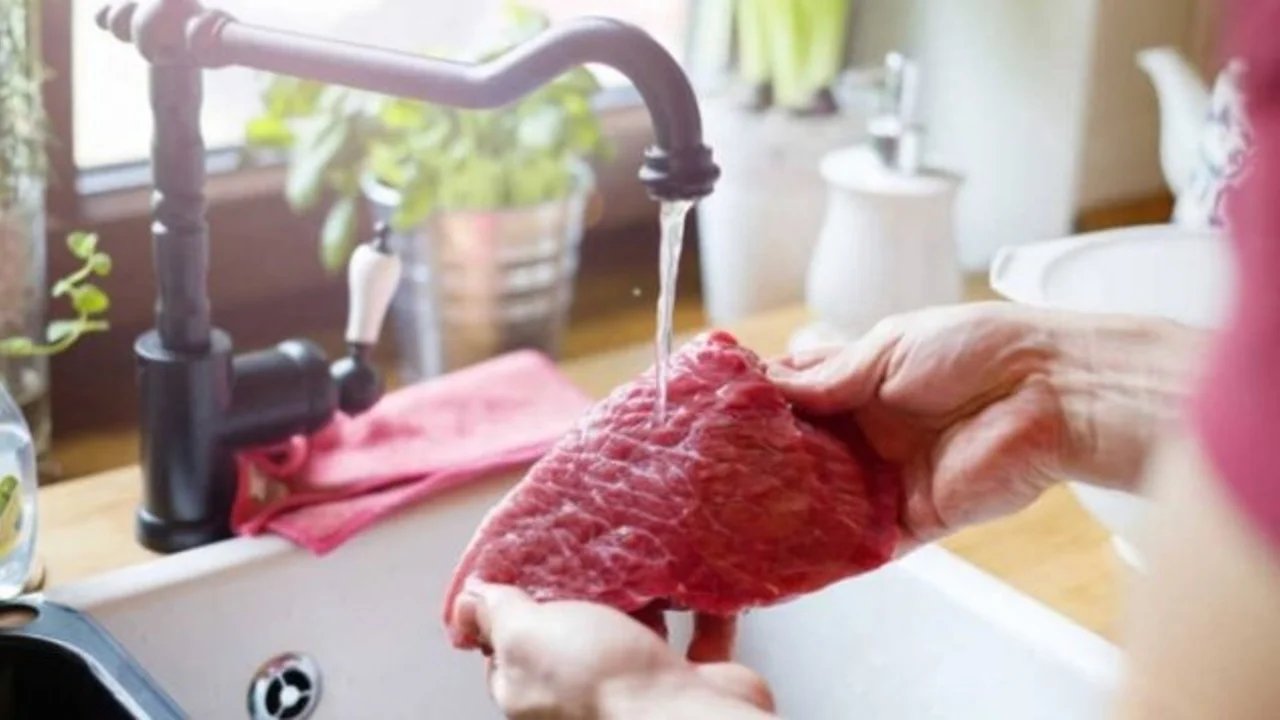 persona lavando carne.